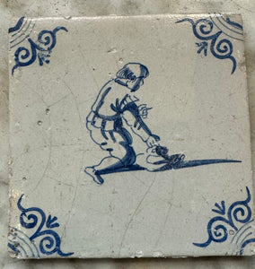 T52) 17 th century delft tile with child playing