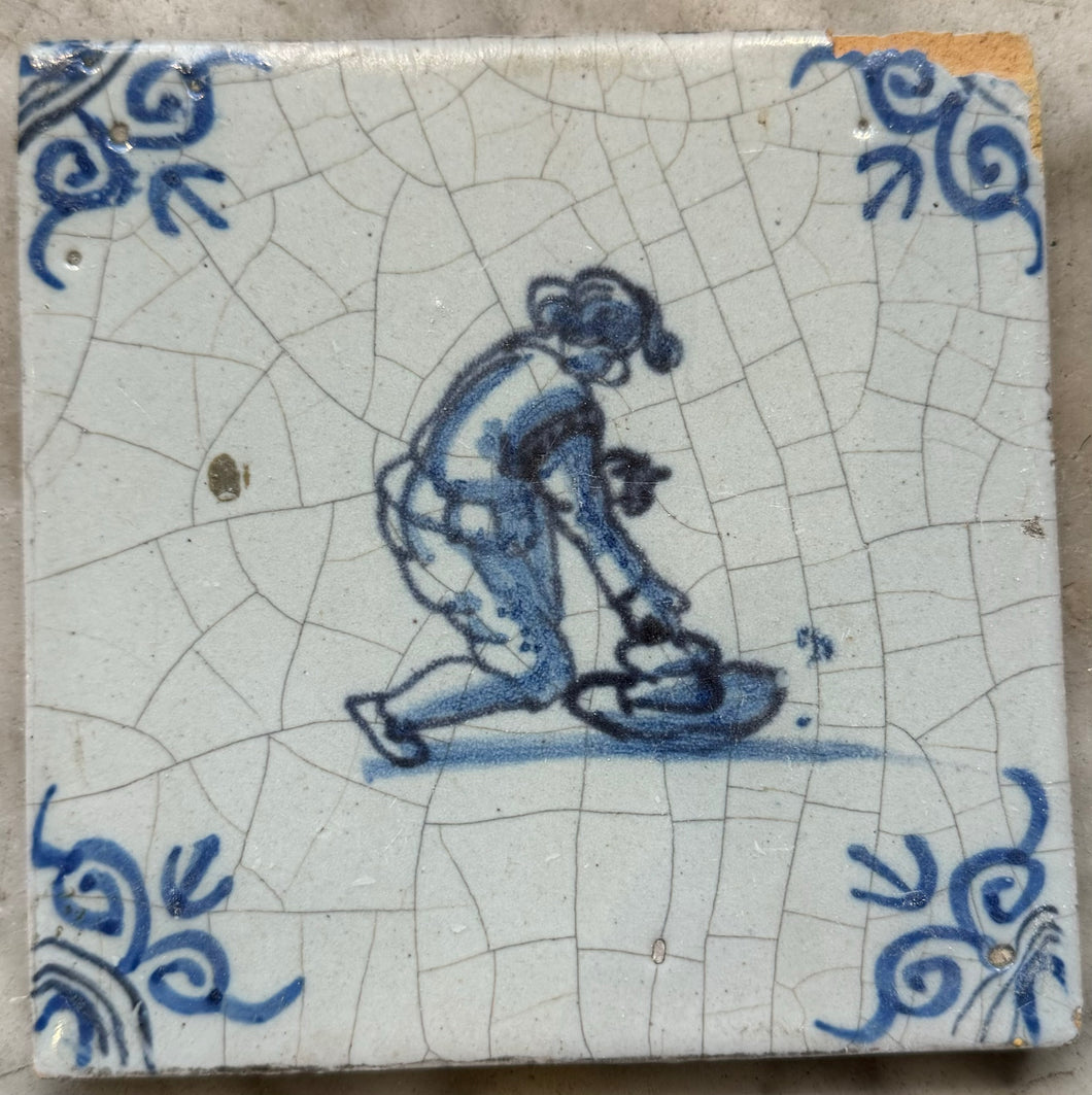 T50)delft 17 th century tile with child playing with a had ( goed)