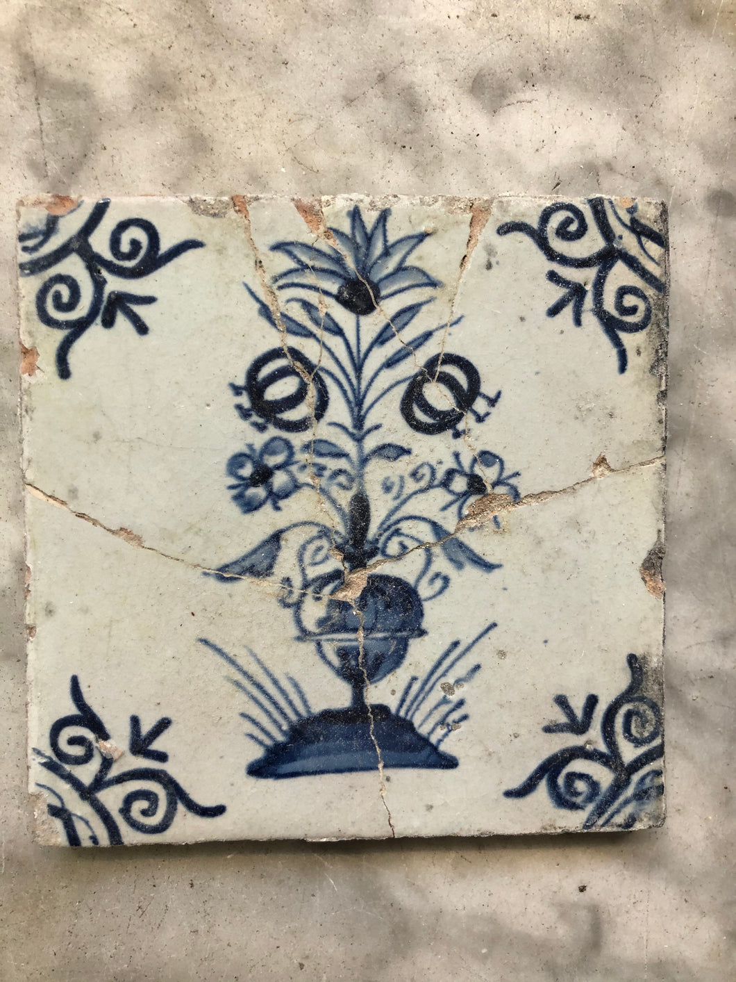 17 th century delft tile with flower vase